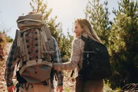 Couple with backpacks hiking on mountain
